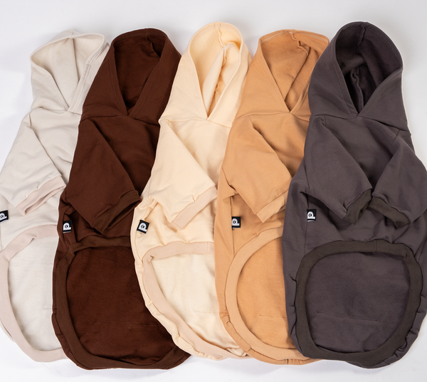 Five dog hoodies in beige, brown, buttercream, tan and dark gray on a white background